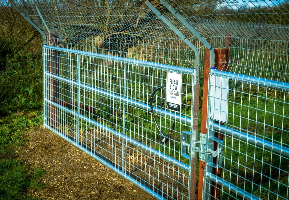 Vehicle and pedestrian gates, including a buried telegraph pole and a gravelled area to prevent burrowing